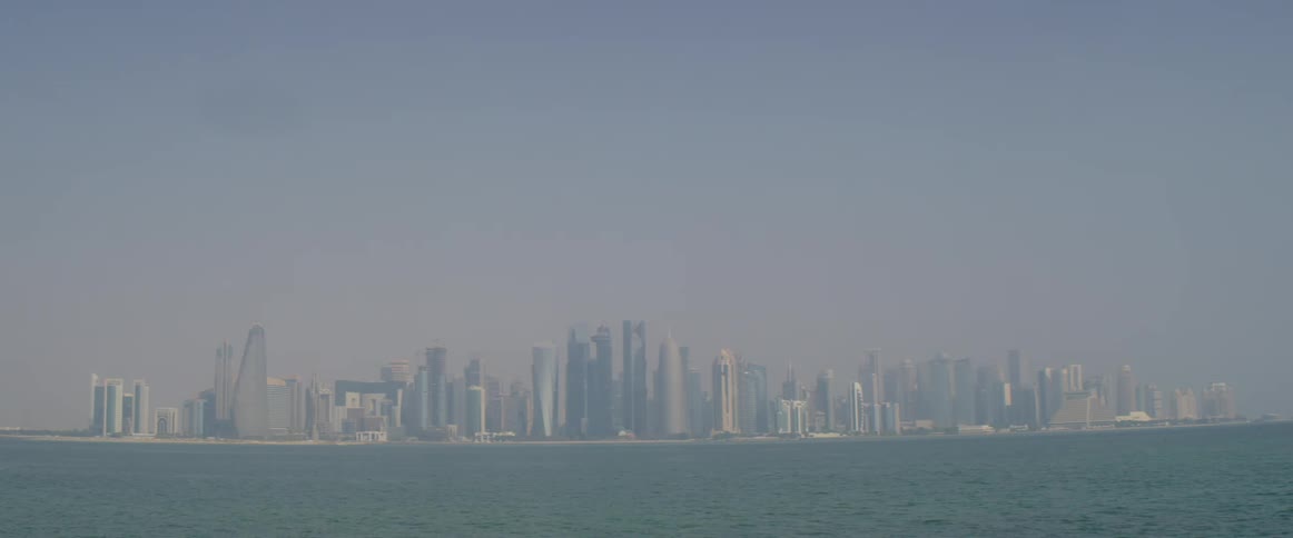 The city is over the water past the fog