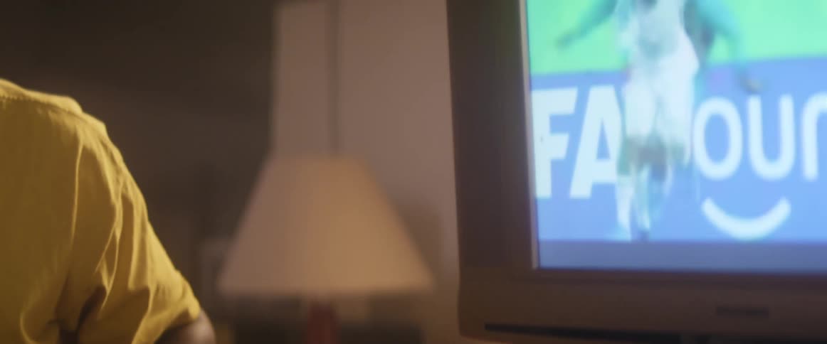 A man watches a soccer game on a television indoors