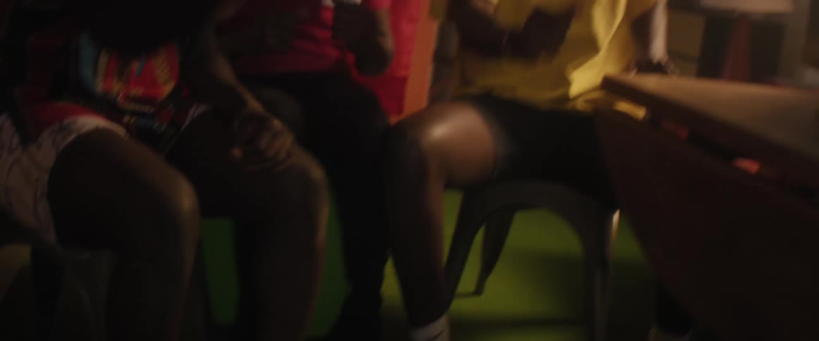 Happy young friends celebrate and dance while sitting at home watching a game on television
