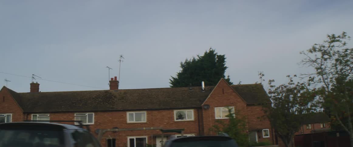 Brick apartment buildings in a neighborhood with a several trees around