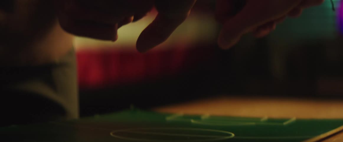 Couple playing with their hands over a tabletop soccer field celebrate holding hands