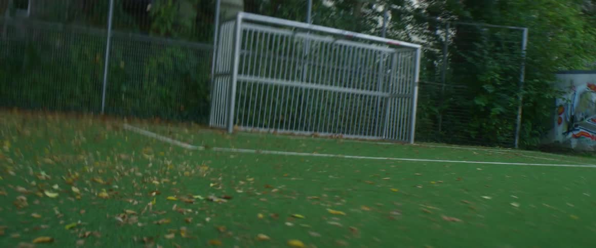 Soccer ball being kicked on a soccer field into a goal by a player