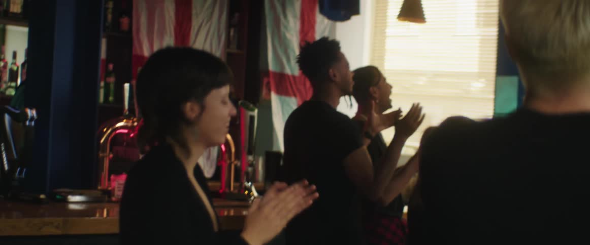 British football fans watch football match on television in bar