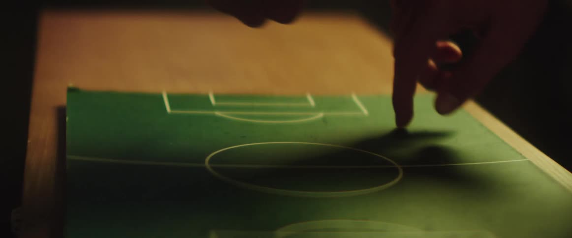 A view of people pointing at a soccer field drawing