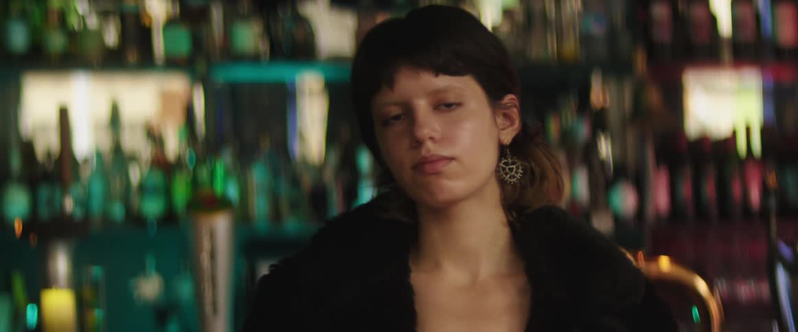 A woman is standing inside of a bar