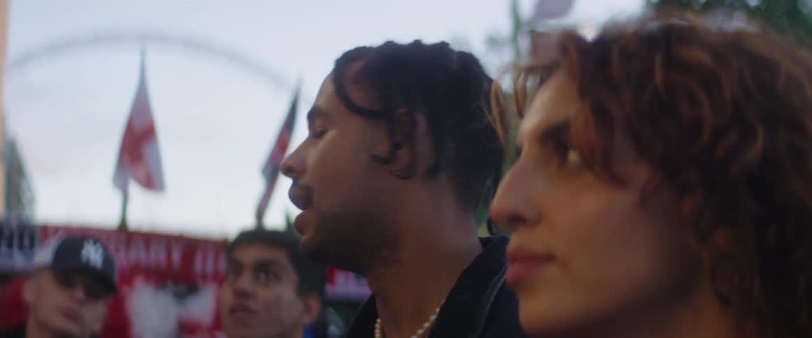 Two people in a crowd are talking to each other