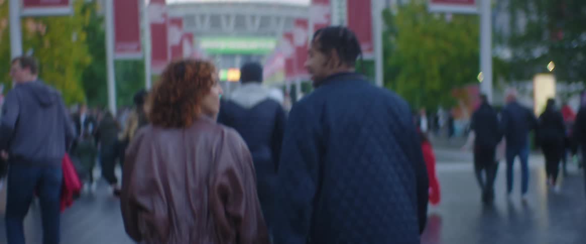 Couple walking on a crowded boulevard in the citys downtown at evening