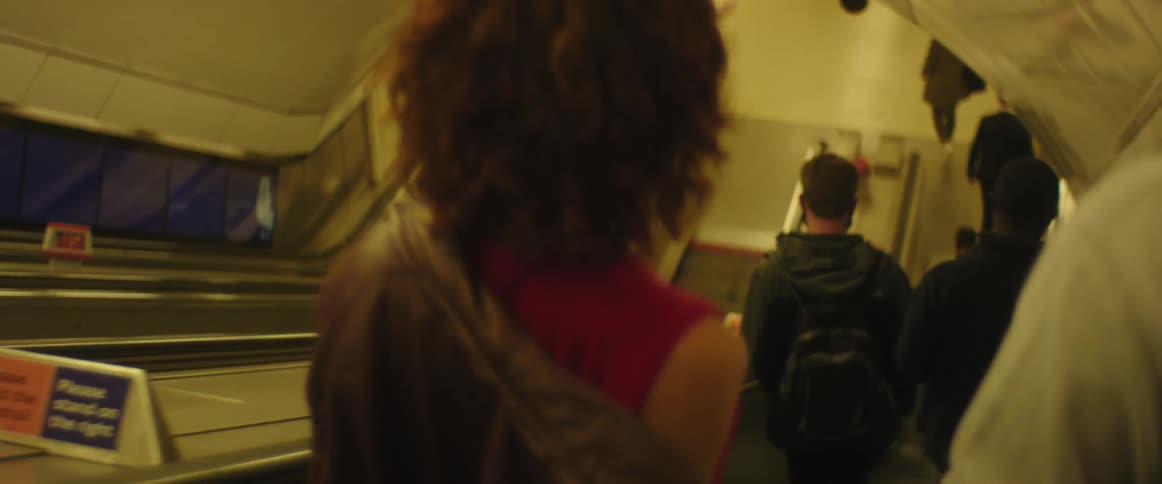 A group of people going down an escalator in a building