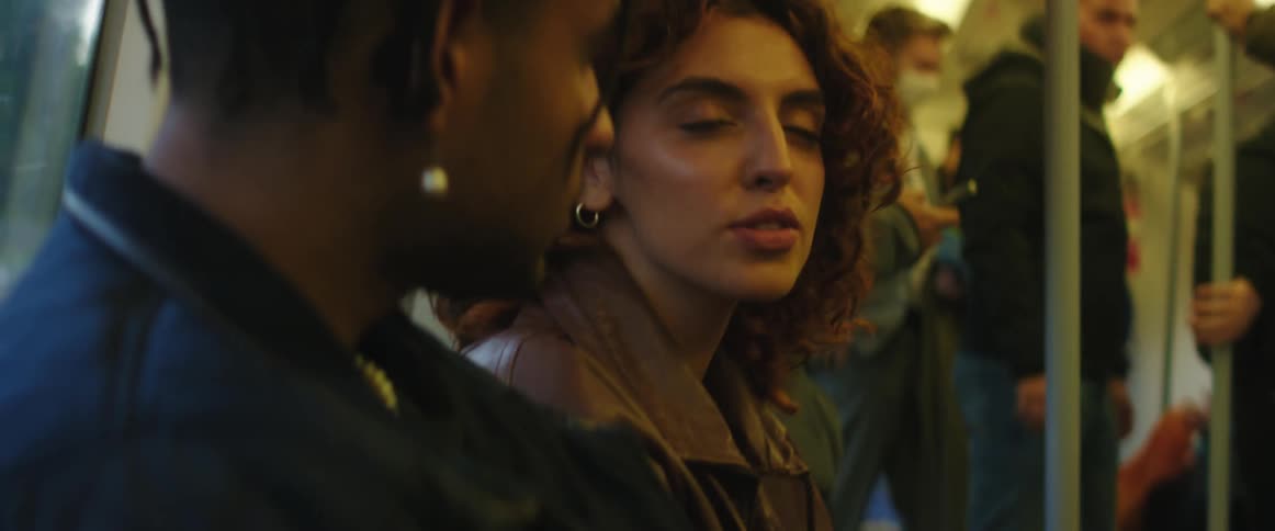 A woman talks with the man sitting next to her on a bus during the day