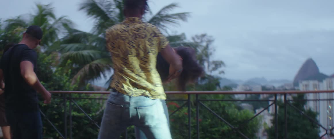 Men and women are dancing outdoors at dusk