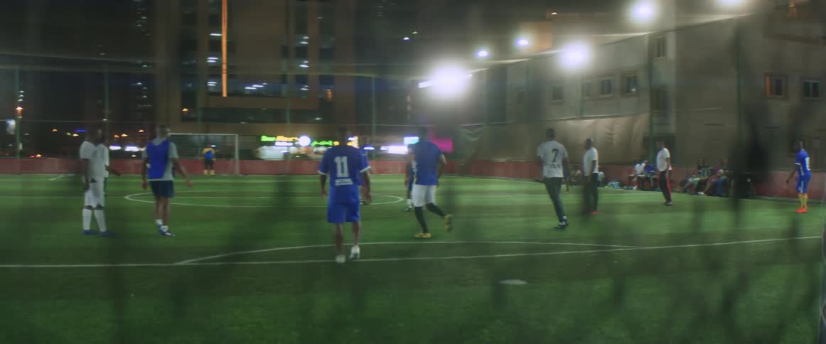 Two teams are playing soccer against each other at night