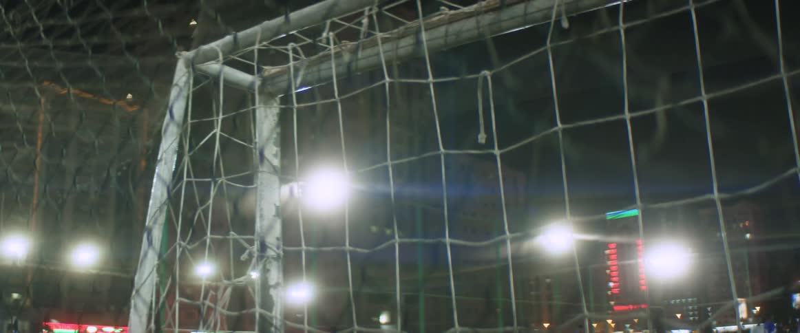 Bright lights neon signs light up a soccer stadium at night