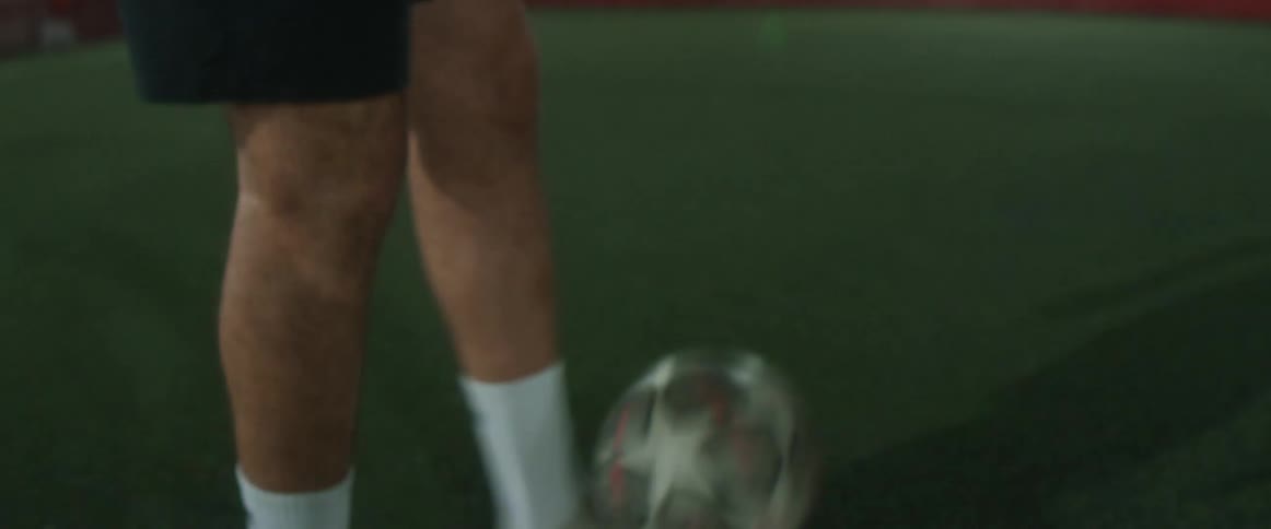 A person kicking a soccer ball outdoors