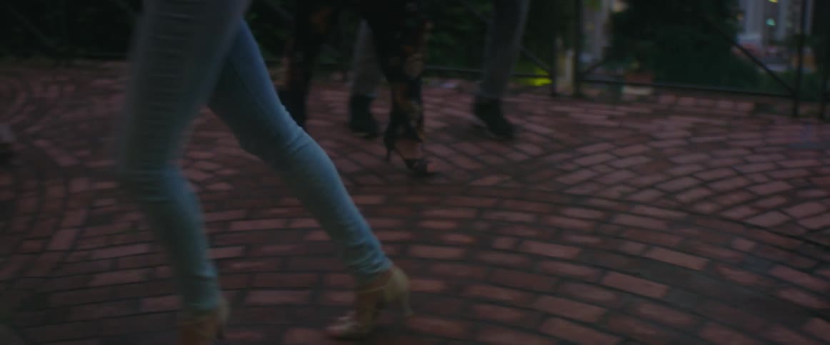 Men and women are dancing outdoors at dusk