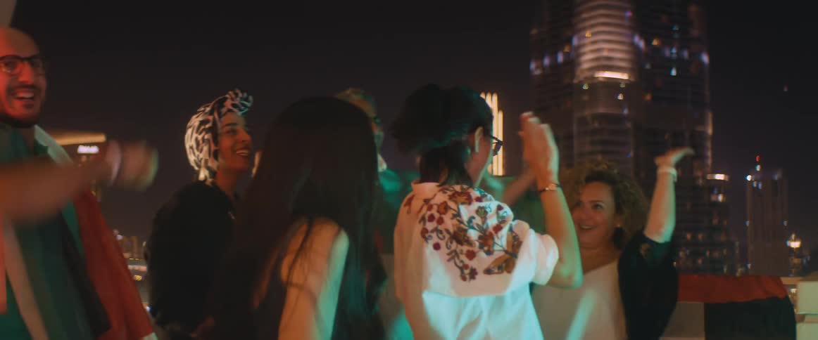 People cheer while watching something on the terrace