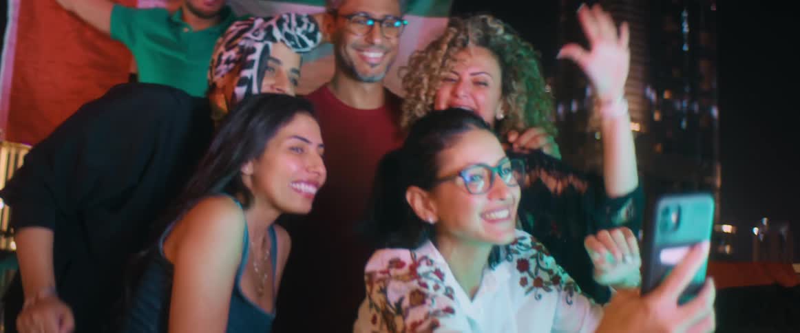 A group of people pose for a selfie at night