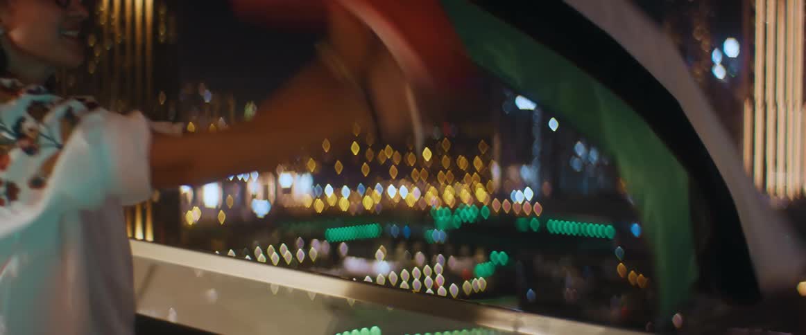 A woman is waving a flag near a window at night