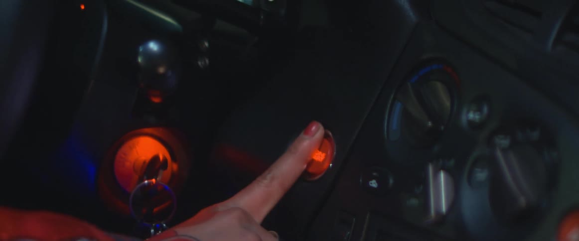 Womans finger pushes push button to start the car