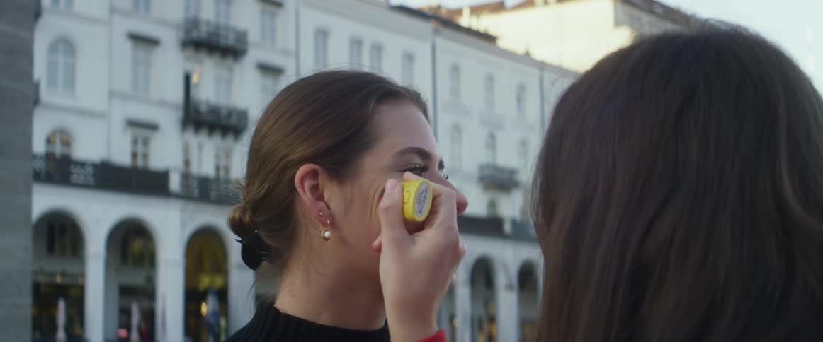 Two women are outdoors in a downtown city in spring