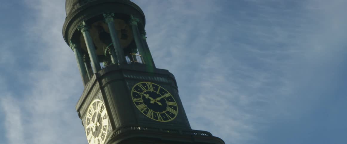A clock tower is topped with columns and a dome