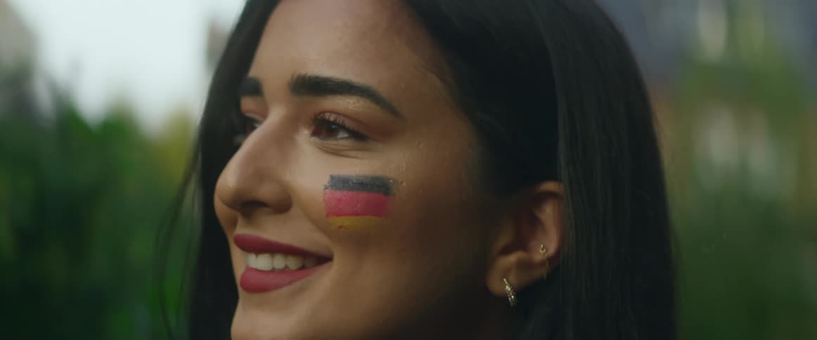 Woman with face paint on cheek smiles