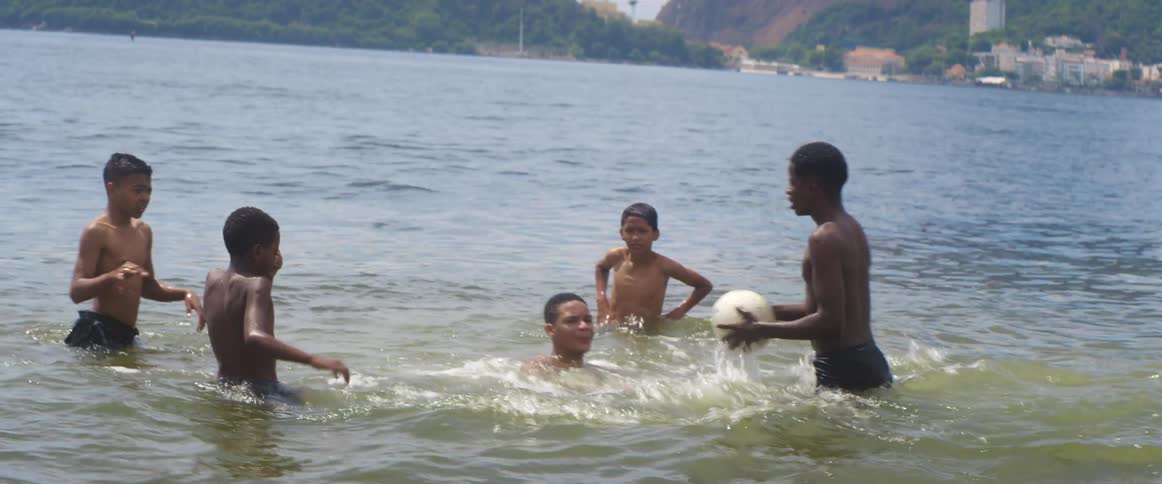 A view of people playing with a ball in the ocean