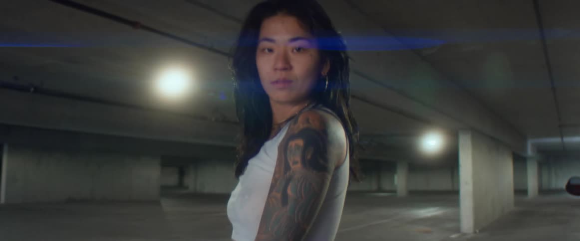 A woman is standing in an empty parking lot