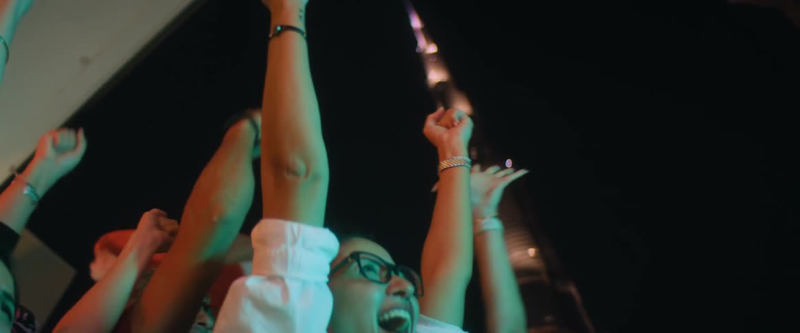 Group of friends watching a game celebrate together in the city at night