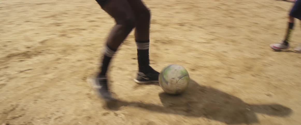 A group of kids are playing soccer outdoors in spring