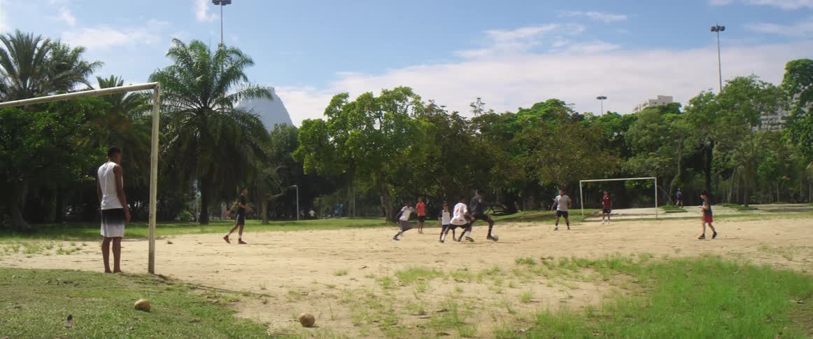 Group of friends playing soccer on a park in the city at day