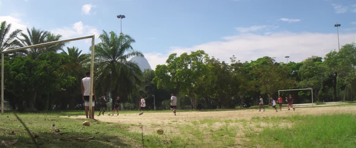 Group of friends playing soccer on a soccer field inside a park