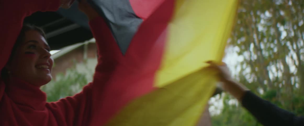 Two women are holding a flag outdoors