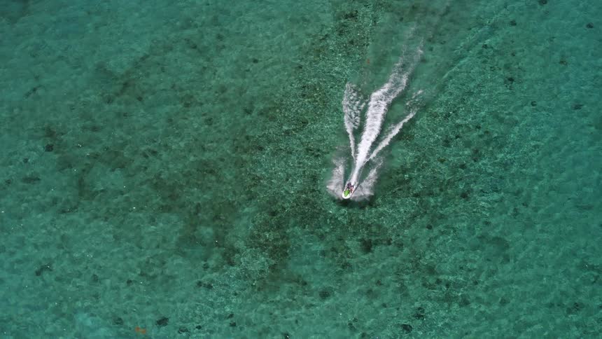 A person is driving a boat through a body of water
