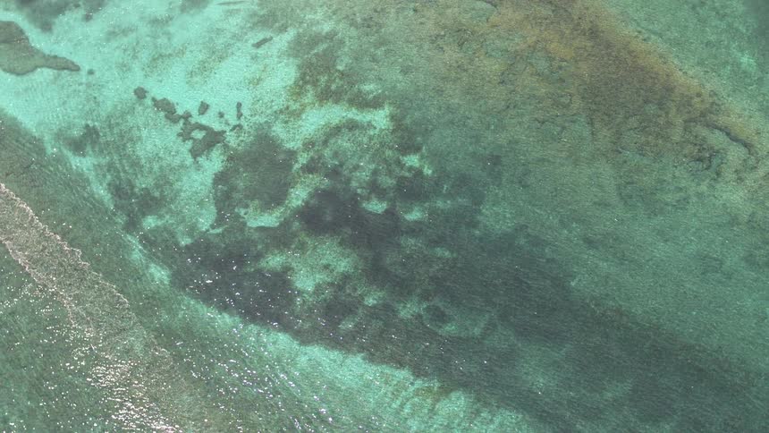 Aerial view of ocean water is displayed at midday