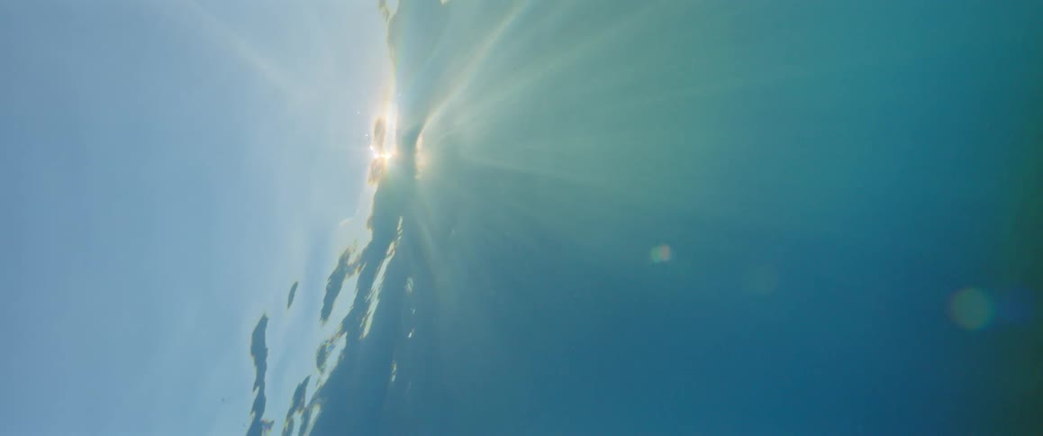 Sunlight shines and through the surface of the blue water