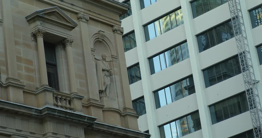 A statue on a big stone building in a city