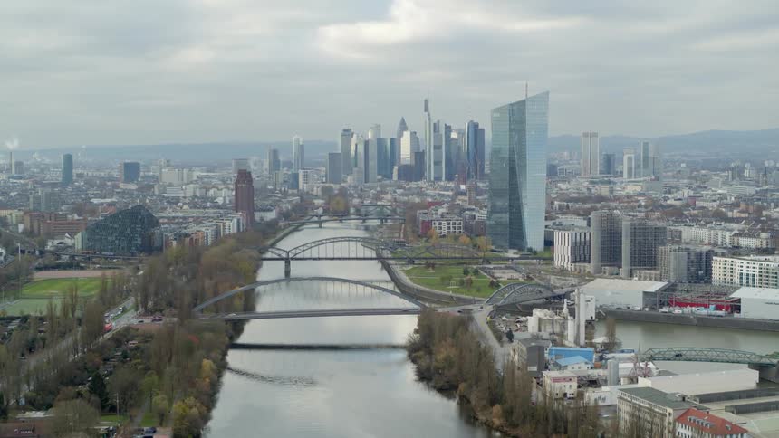 Aerial view of a river flowing through a downtown city is displayed
