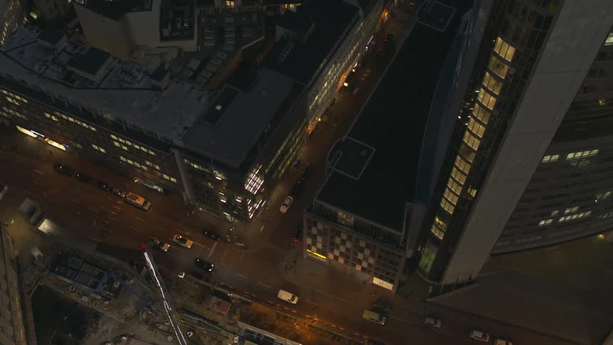 Aerial view of cars driving through a downtown city at night