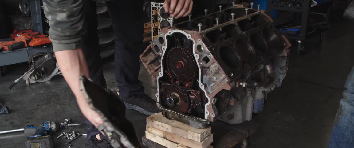Two mechanics repair engine at garage