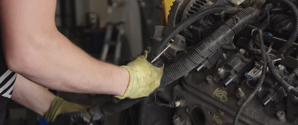 A man is working on an engine of a car