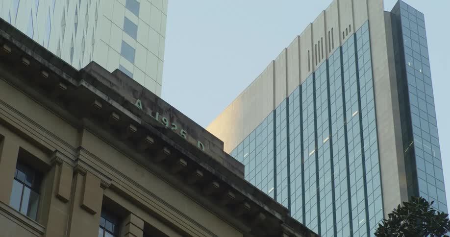 Tall skyscrapers loom over a smaller building downtown