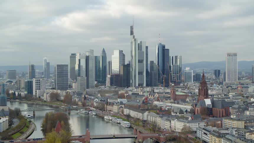 Aerial view of river with high rise buildings under cloudy sky in the city