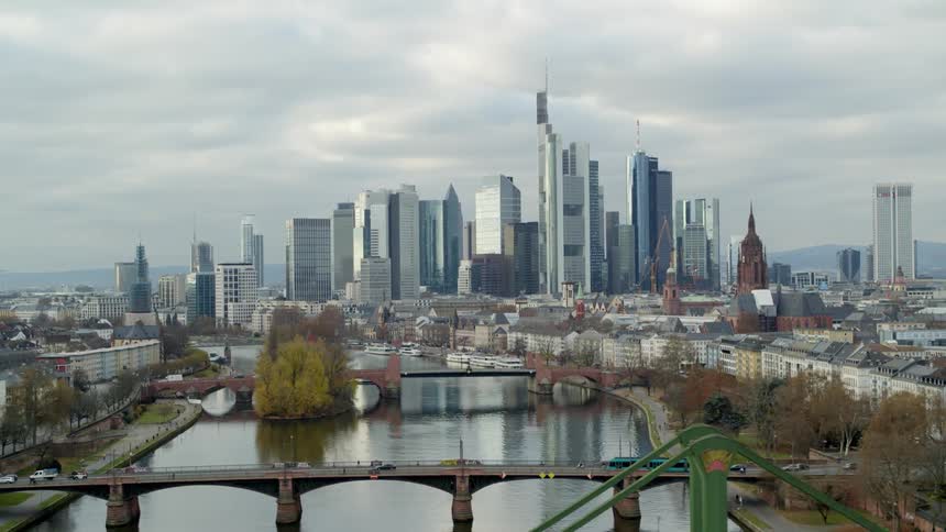 Cars are driving on a bridge near a downtown city