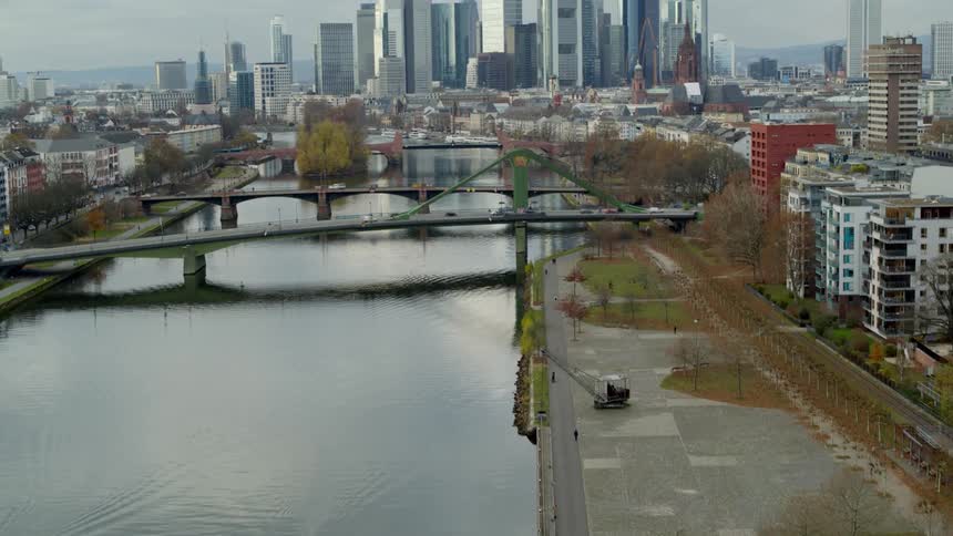 Aerial view of bridges over river and city skyline under clouds