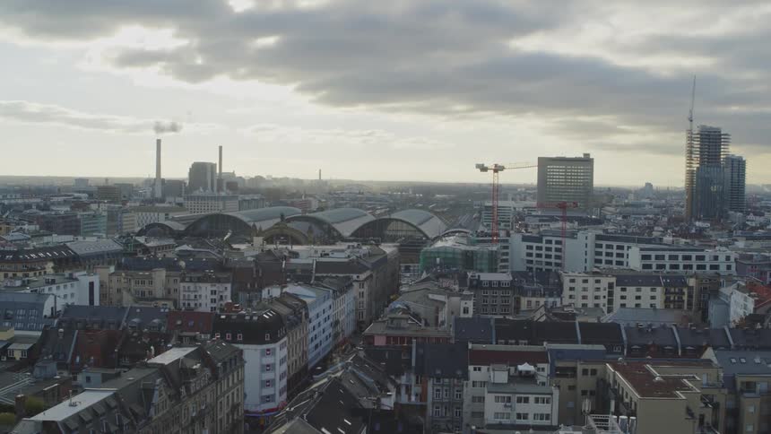 An aerial view of apartment buildings and high rise buildings with construction cranes in a city