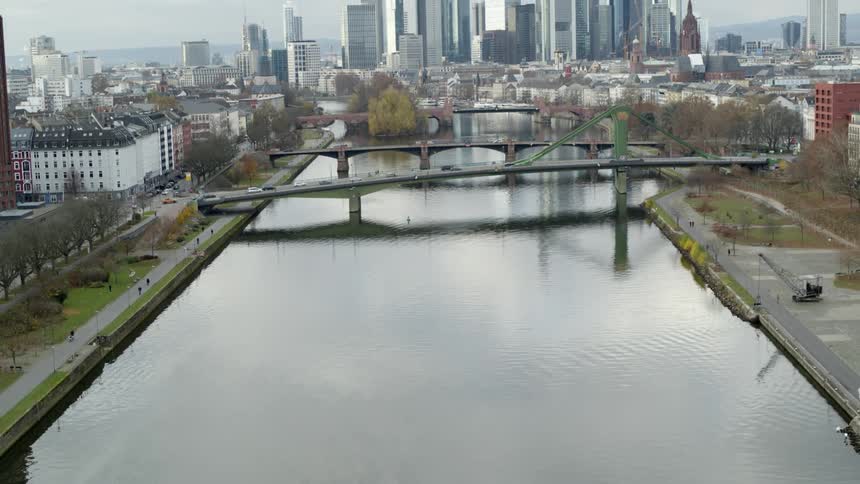 Aerial view of bridges over river with city skyline on cloudy day