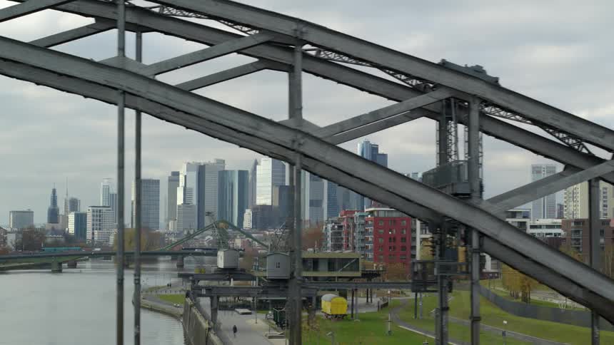 Tall skyscrapers and a river bridge in a city on a cloudy autumn day