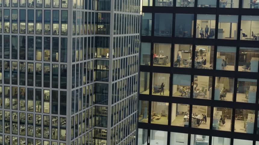 An aerial view of office employees working inside a tall urban skyscraper