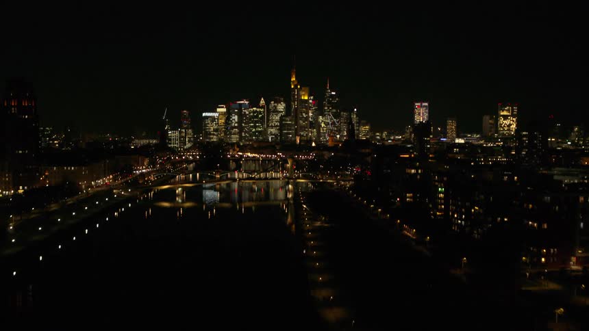 Aerial view of bridges over river and illuminated high rise buildings in the city at night