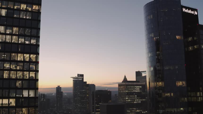 The sun is setting behind the downtown city skyline